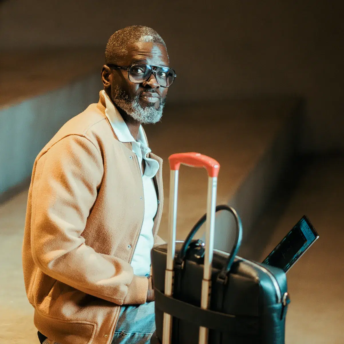 Homme assis avec valise et ordinateur portable